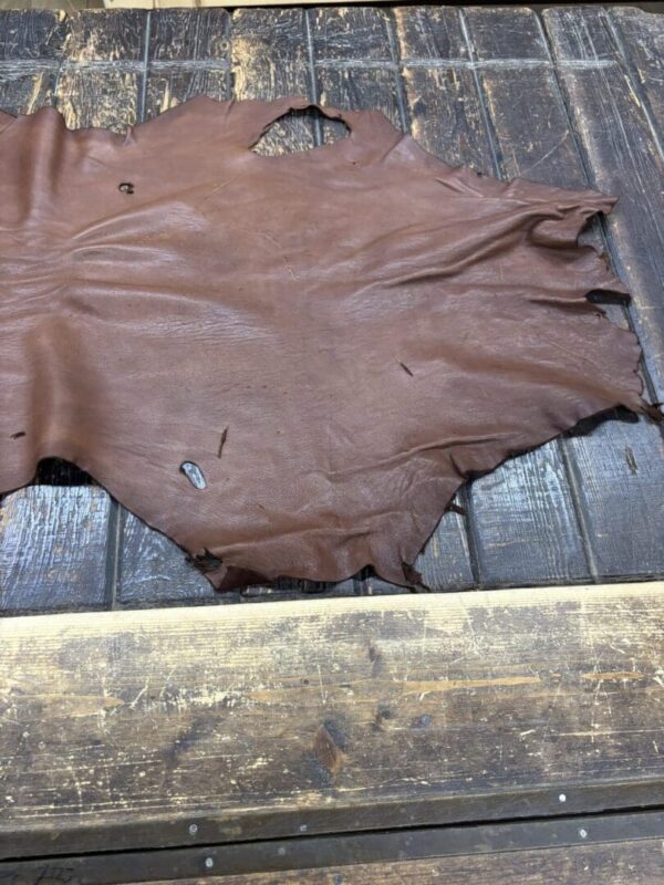 IMG_1923 Brown leather hide on wooden surface.