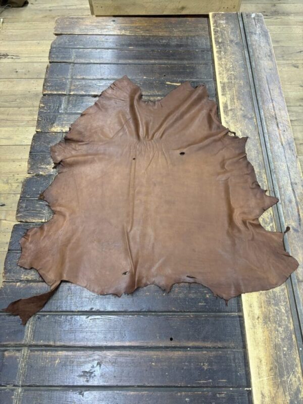 Brown leather hide on wooden table.