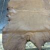 Brown leather hide on wooden surface.