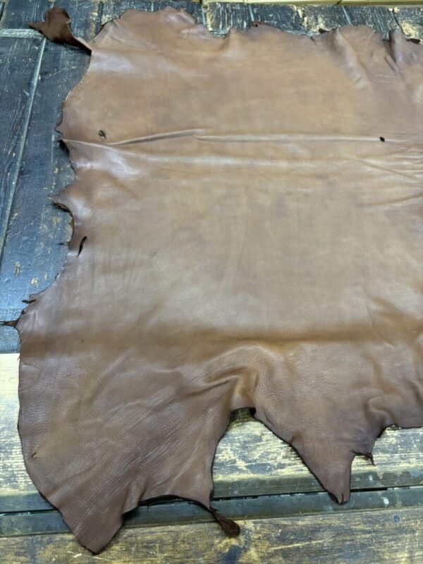 Brown leather hide on wooden surface.