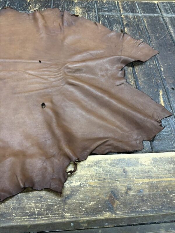 Brown leather hide on wooden surface.