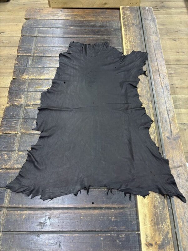 Black leather hide on wooden table.