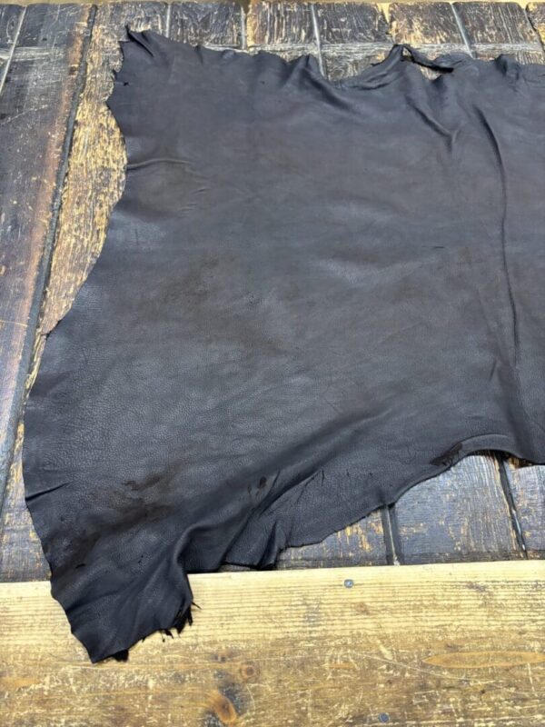 Dark leather hide on wooden surface.