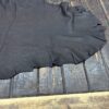 Black leather hide on wooden surface.