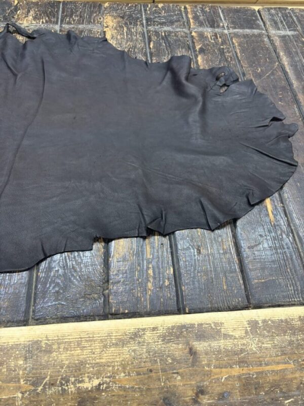 Black leather hide on wooden surface.