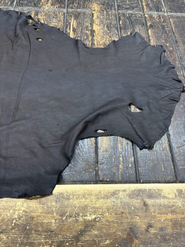 Worn black leather on wooden floor.