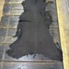 Black animal hide on wooden surface.