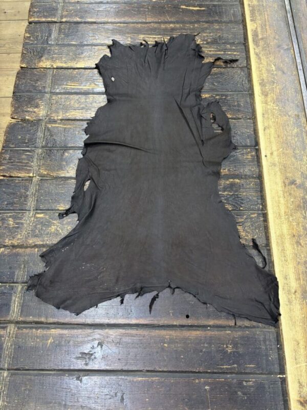 Black animal hide on wooden surface.