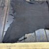 Dark leather hide on wooden surface.
