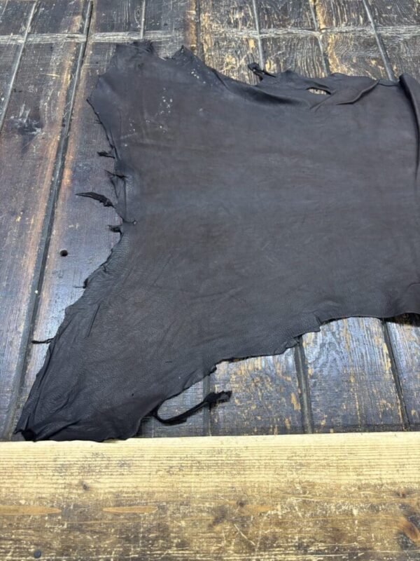 Dark leather hide on wooden surface.