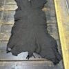 Black leather hide on wooden surface.