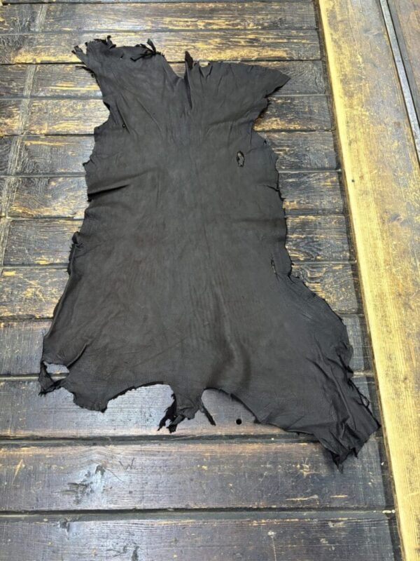 Black leather hide on wooden surface.