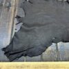 Dark leather hide on wooden surface.