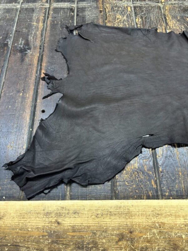 Dark leather hide on wooden surface.