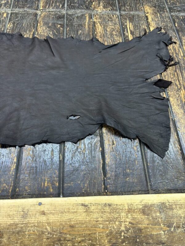 Dark leather hide on wooden surface.