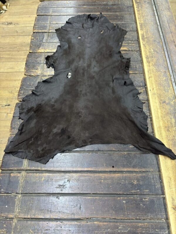 Black animal hide on wooden surface.