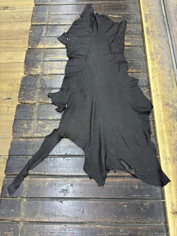 Black animal hide on wooden floor.