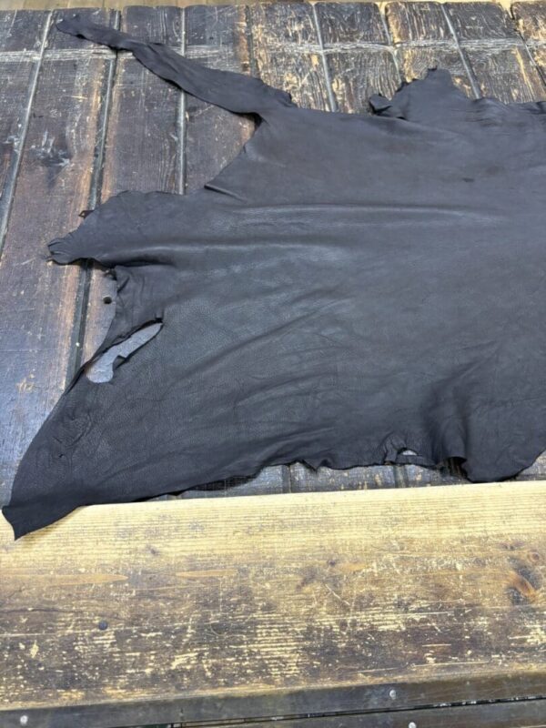 Black leather hide on wooden surface.