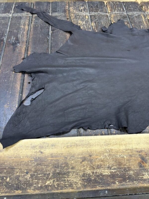 Black leather hide on wooden surface.