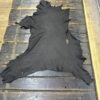 Black leather hide on wooden surface.