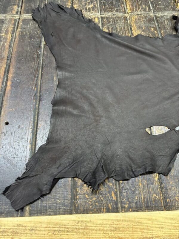 Black leather hide on wooden surface.