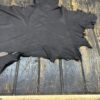 Black leather hide on wooden surface.