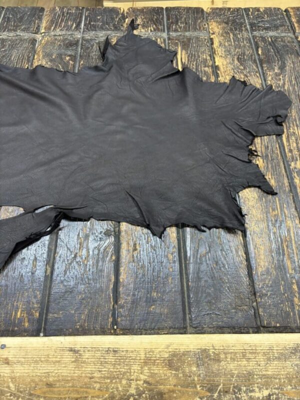 Black leather hide on wooden surface.