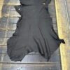 Black leather hide on wooden surface.