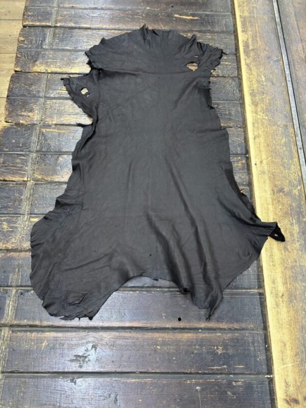 Black leather hide on wooden surface.