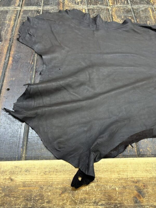 Black leather hide on wooden surface.