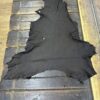Black leather hide on wooden surface.