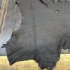 Dark leather hide on wooden surface.