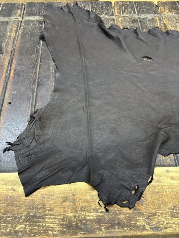 Dark leather hide on wooden surface.
