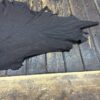 Black leather hide on wooden table.