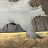 Gray leather hide on wooden surface.