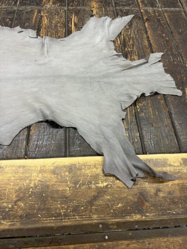 Gray leather hide on wooden surface.