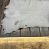 Gray leather hide on wooden surface.