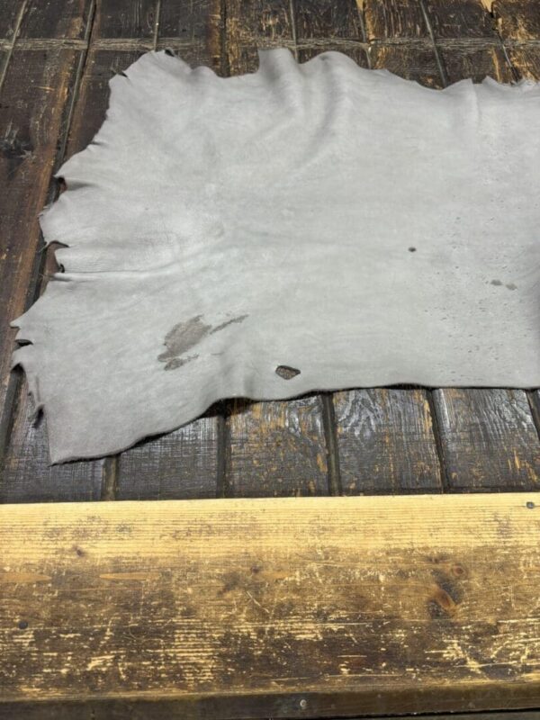 Gray leather hide on wooden surface.