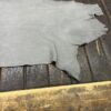 Gray leather hide on wooden surface.