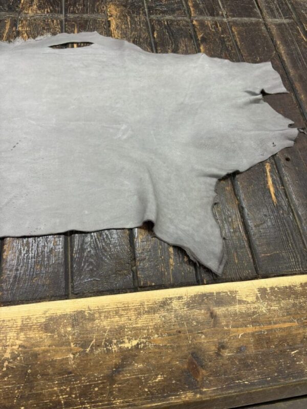Gray leather hide on wooden surface.