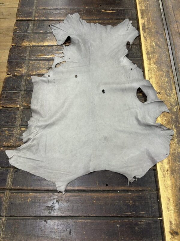 Gray leather hide on wooden surface.