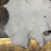 Gray leather hide on wooden surface.