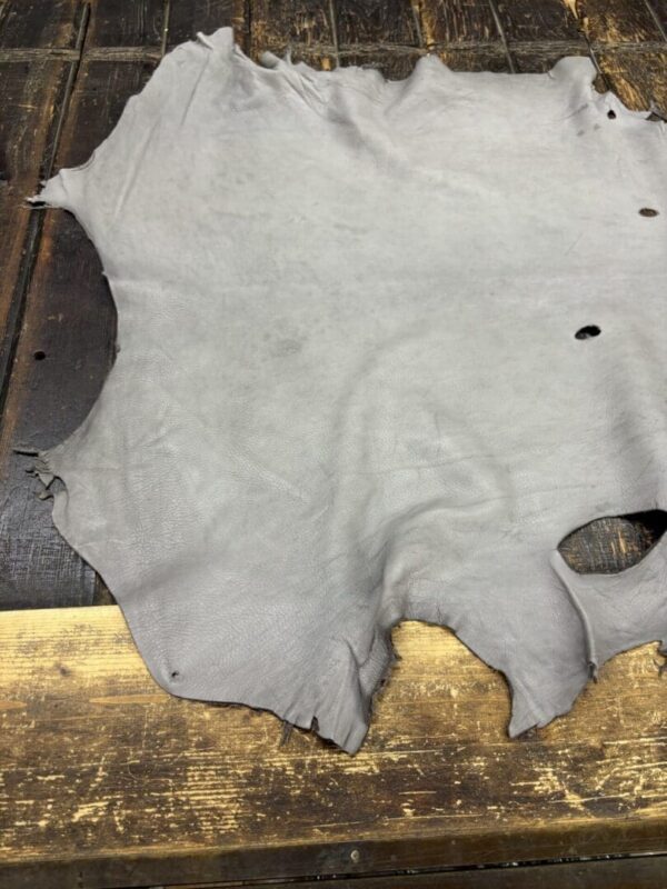Gray leather hide on wooden surface.