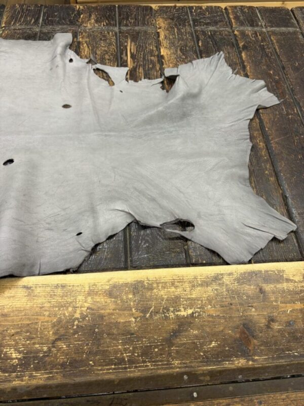 Worn leather hide on wooden surface.