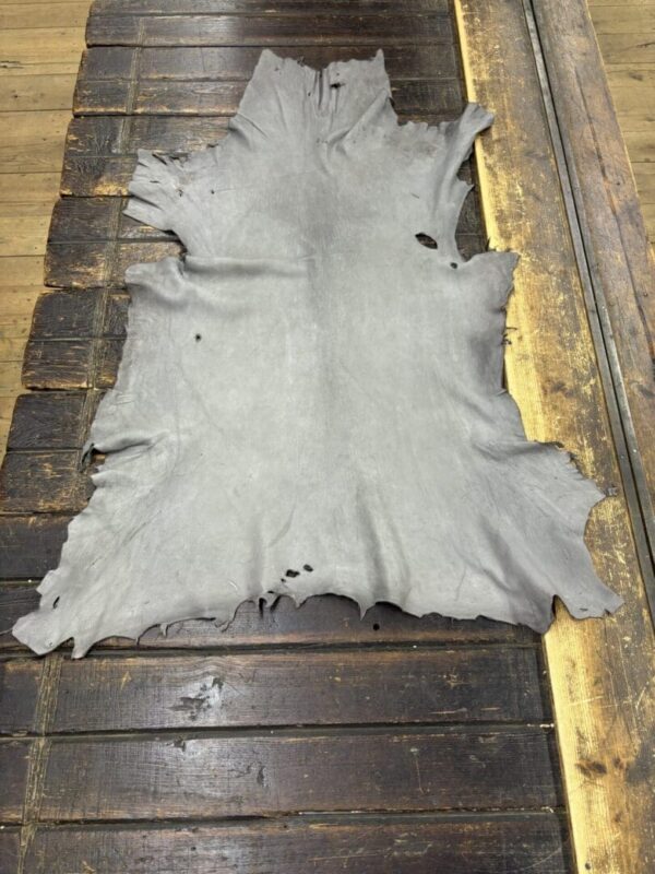 Gray animal hide on wooden surface.