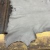 Gray leather hide on wooden surface.