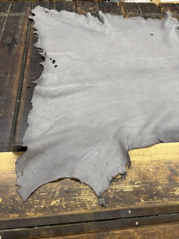 Gray leather hide on wooden surface.