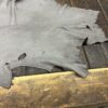 Grey leather piece on wooden surface.