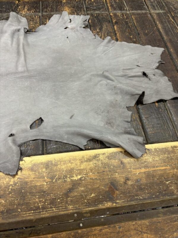 Grey leather piece on wooden surface.
