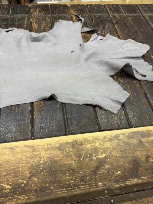 Gray leather hide on wooden table.